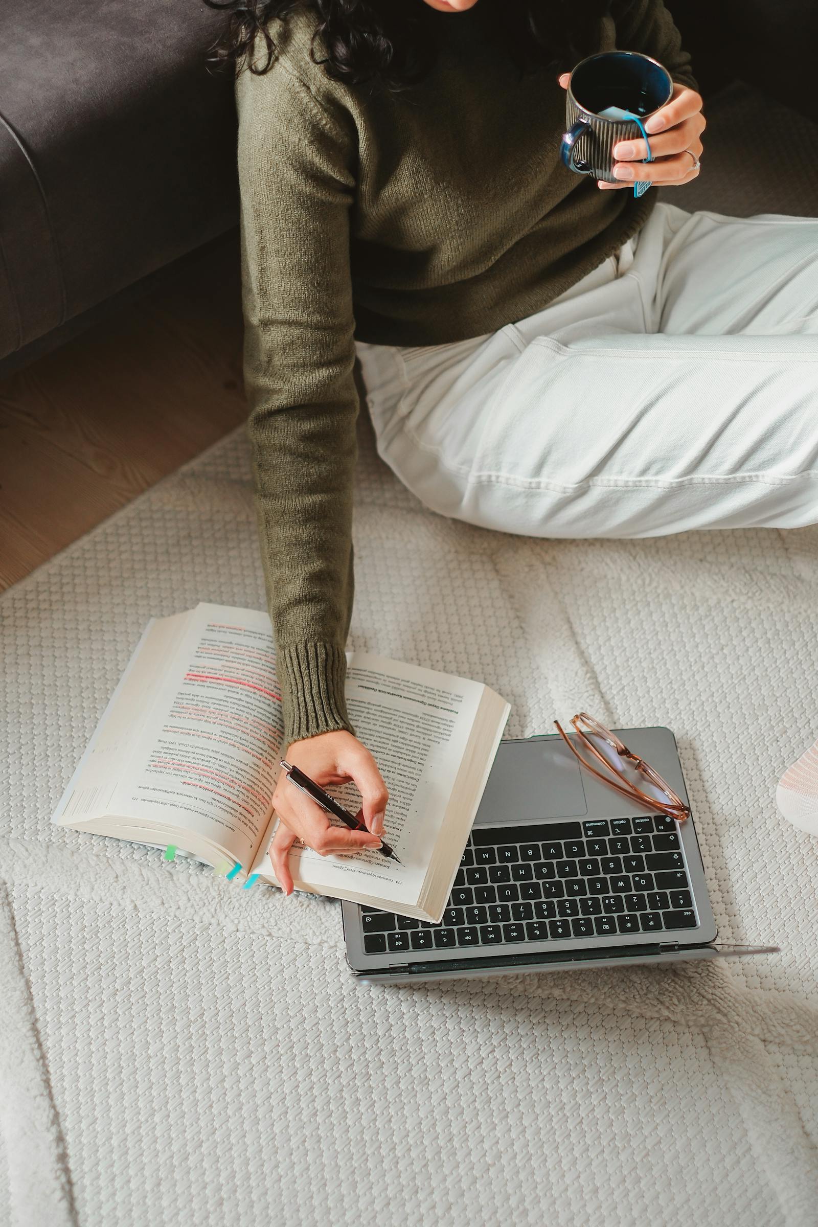 A young woman studying with her laptop and a cup of tea at home — exam preparation done at her own pace.